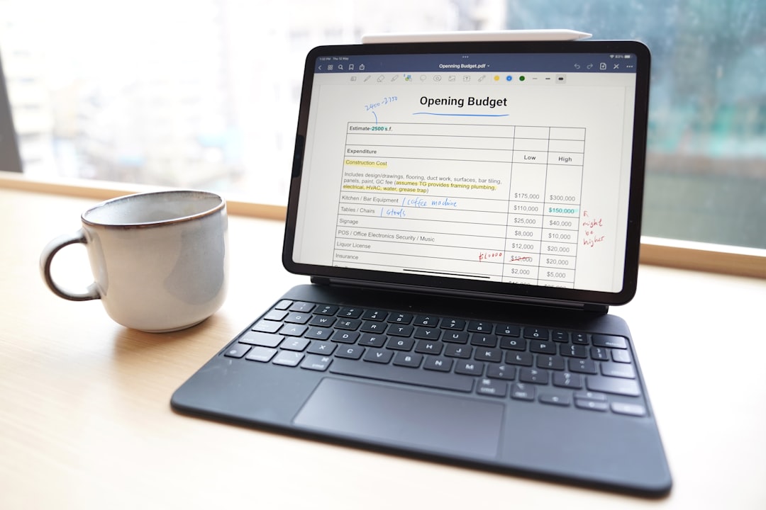 Small business owner reviewing financial reports on bookkeeping software.