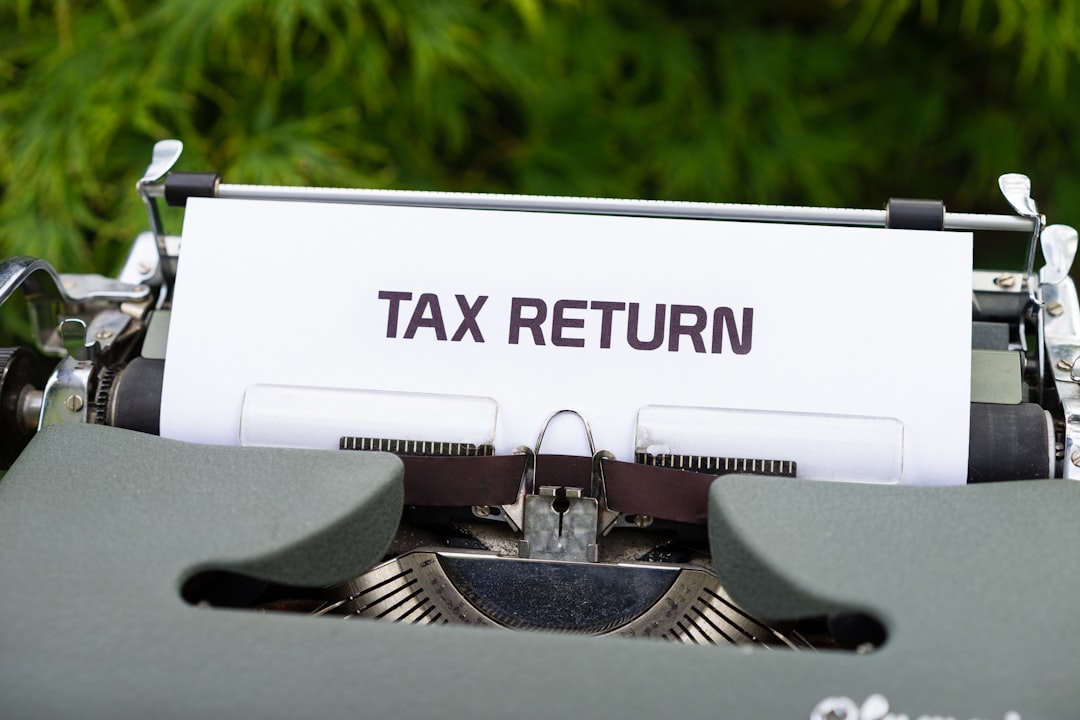Small business owner reviewing tax deductions refunds on accounting software for 2024.